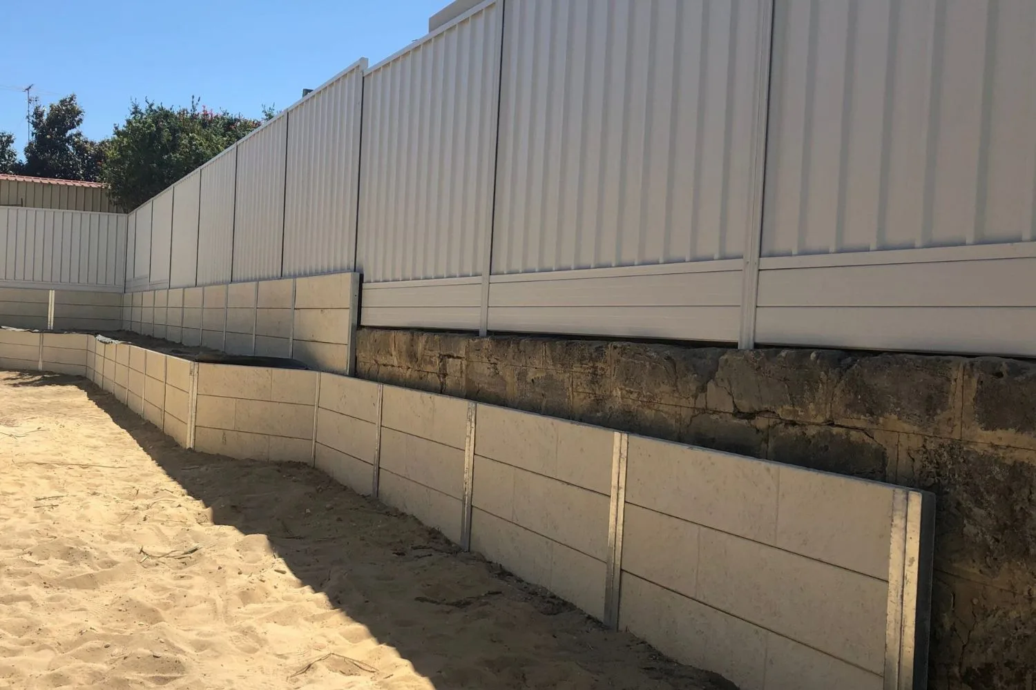 Curved concrete sleeper retaining wall with lit garden bed