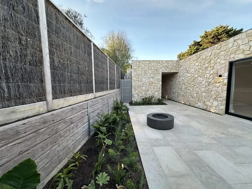 Sandstone retaining wall and paved courtyard completed by our Mornington Peninsula team